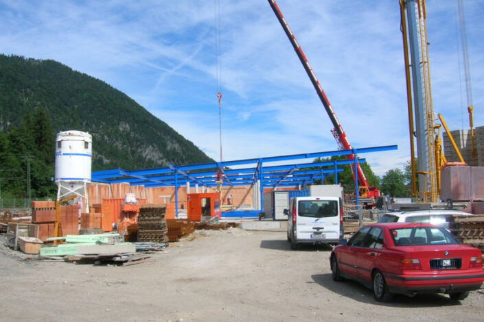 Baustelle mit blauer Stahlkonstruktion und Kran beim Neubau eines Einkaufscenters