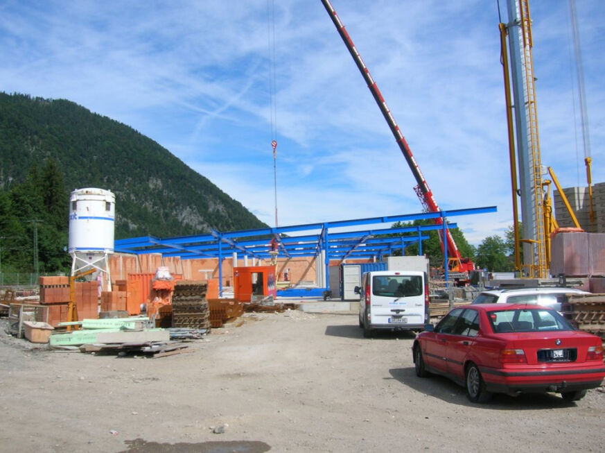 Baustelle mit blauer Stahlkonstruktion und Kran beim Neubau eines Einkaufscenters