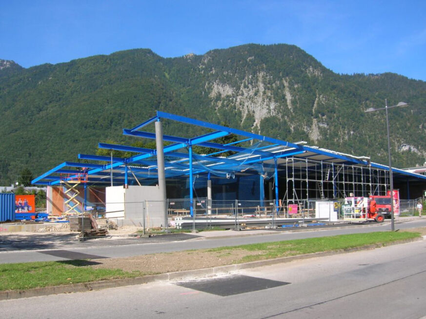 Neubau eines Einkaufscenters mit blauer Stahlkonstruktion und moderner Hallenstruktur