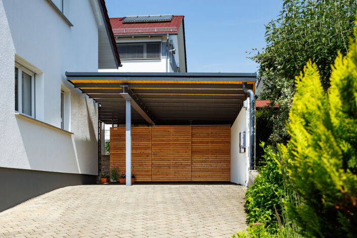 Carport mit Rombus-Holzverkleidung und Flachdach in moderner Ausführung