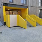 Zwei Außentreppen mit gelber Stahlblechverkleidung und montierten Edelstahlhandläufen