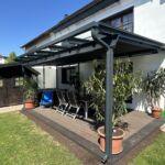 Moderne Terrassenüberdachung aus Stahl mit Glasdach und Sonnenschutz