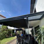 Terrassenüberdachung mit Glasdach und integrierter Unterdachmarkise in modernem Design