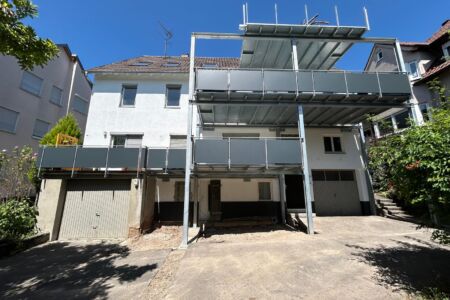 Dreistöckiger Balkonanbau mit verzinkter Stahlkonstruktion und grauen Aluminiumfüllungen an einem Bestandsgebäude