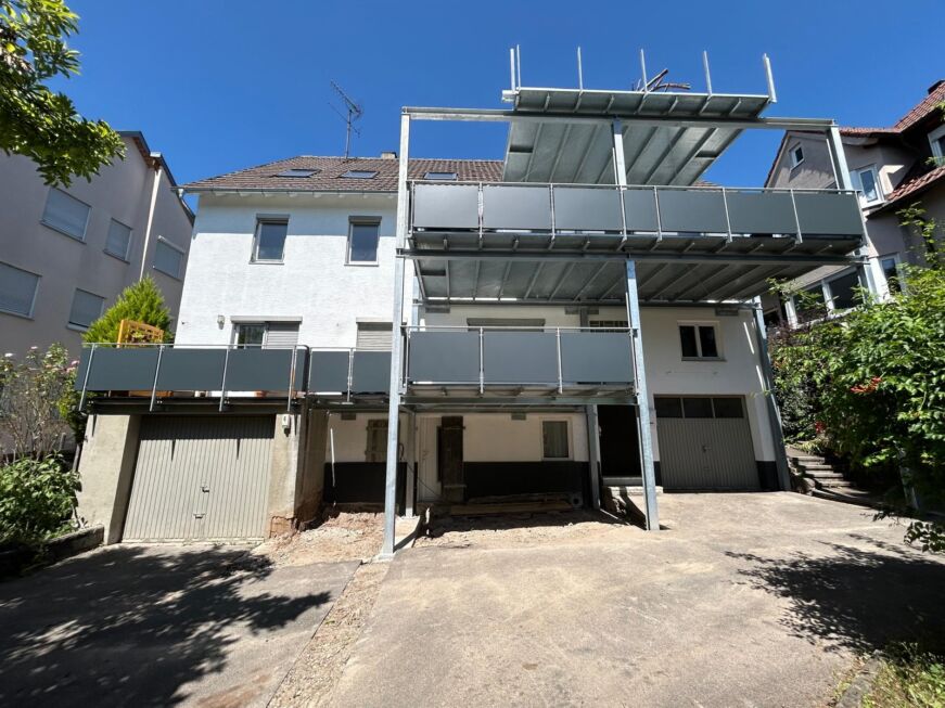 Dreistöckiger Balkonanbau mit verzinkter Stahlkonstruktion und grauen Aluminiumfüllungen an einem Bestandsgebäude