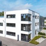 L-förmiges Büro- und Hallengebäude mit moderner Glasfassade und Stahlkonstruktion