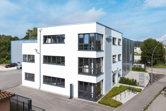 L-förmiges Büro- und Hallengebäude mit moderner Glasfassade und Stahlkonstruktion