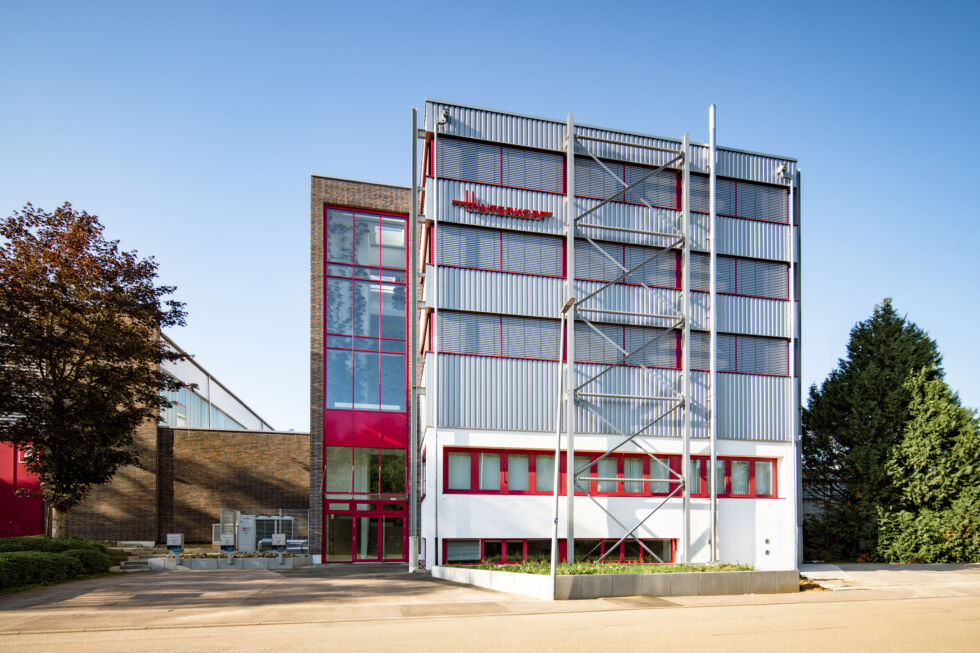 Frontalansicht eines aufgestockten Industriegebäudes mit Sicht auf den neuen Stahlbau