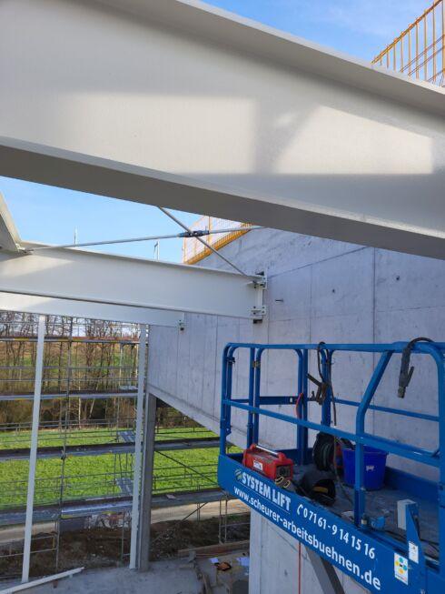 Detailaufnahme eines Stahlträgers mit F30-Brandschutzbeschichtung im Neubau einer Stahlhalle