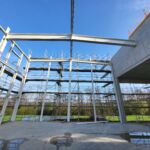 Innenansicht einer Stahlhalle mit beschichteten Stahlträgern und Baugerüsten