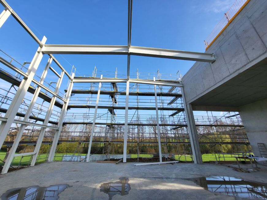 Innenansicht einer Stahlhalle mit beschichteten Stahlträgern und Baugerüsten