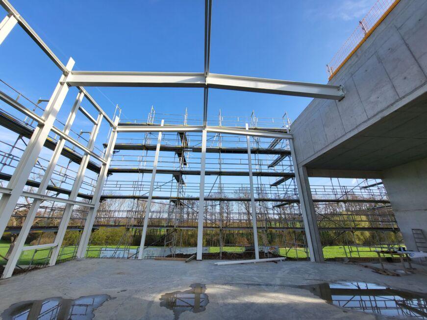 Innenansicht einer Stahlhalle mit beschichteten Stahlträgern und Baugerüsten