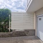 Weißer Sichtschutz aus horizontalen Aluminiumprofilen an Garage