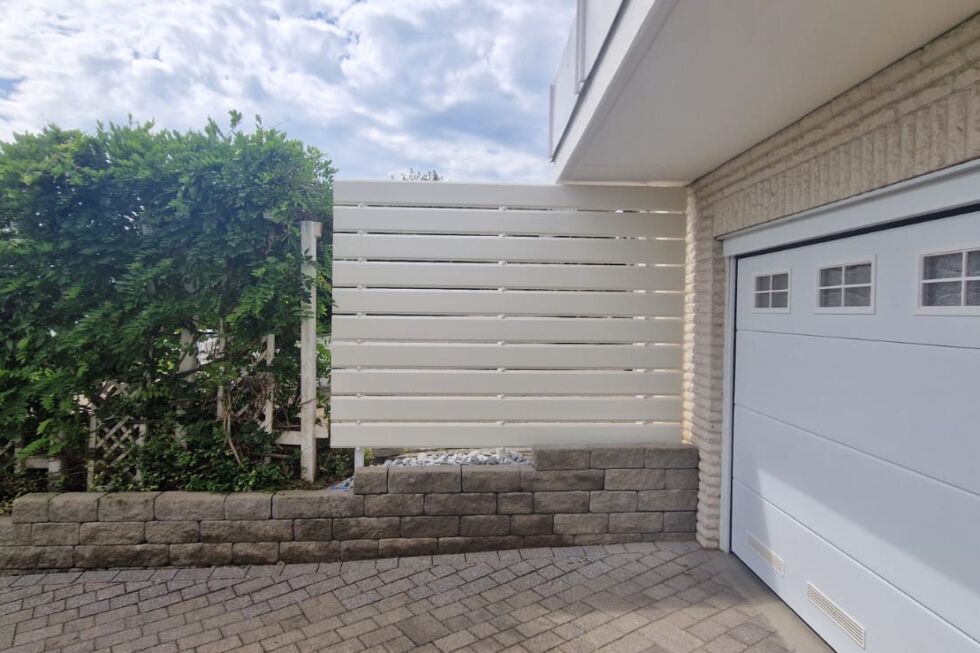 Weißer Sichtschutz aus horizontalen Aluminiumprofilen an Garage