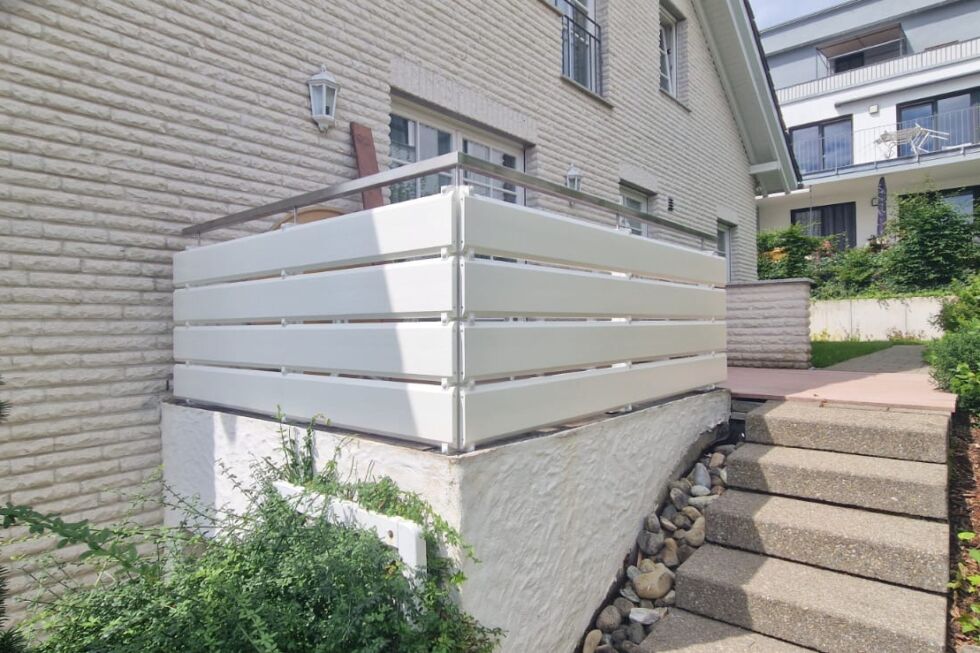 Weiße Terrassenbrüstung aus horizontalen Profilen mit Edelstahlhandlauf