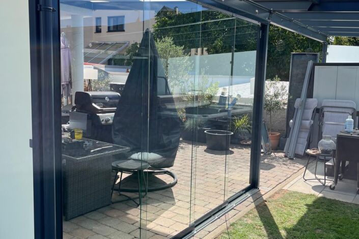 Glas-Schiebewand nachgerüstet an Terrassenüberdachung mit anthrazitfarbener Stahlkonstruktion