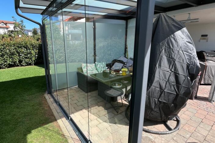 Seitenansicht der nachgerüsteten Glas-Schiebewand unter einer modernen Terrassenüberdachung