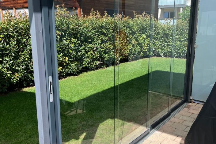 Glas-Schiebewand mit eingelassener Bodenschiene in Terrassenüberdachung