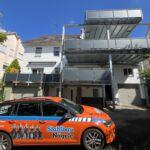 Dreigeschossiger Balkonanbau mit Stahlkonstruktion und Stahlbau Nägele Fahrzeug im Vordergrund