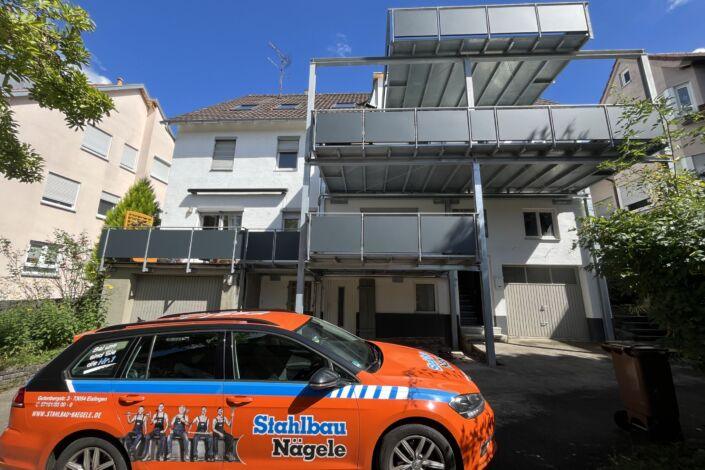 Dreigeschossiger Balkonanbau mit Stahlkonstruktion und Stahlbau Nägele Fahrzeug im Vordergrund