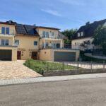 Gesamte Zaunanlage mit Zierelementen auf Brüstungsmauer vor Wohngebäude mit Einfahrt