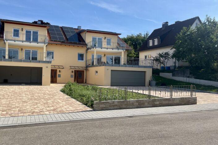 Gesamte Zaunanlage mit Zierelementen auf Brüstungsmauer vor Wohngebäude mit Einfahrt