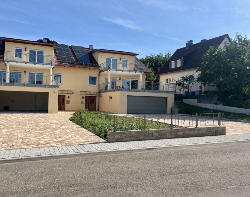 Gesamte Zaunanlage mit Zierelementen auf Brüstungsmauer vor Wohngebäude mit Einfahrt