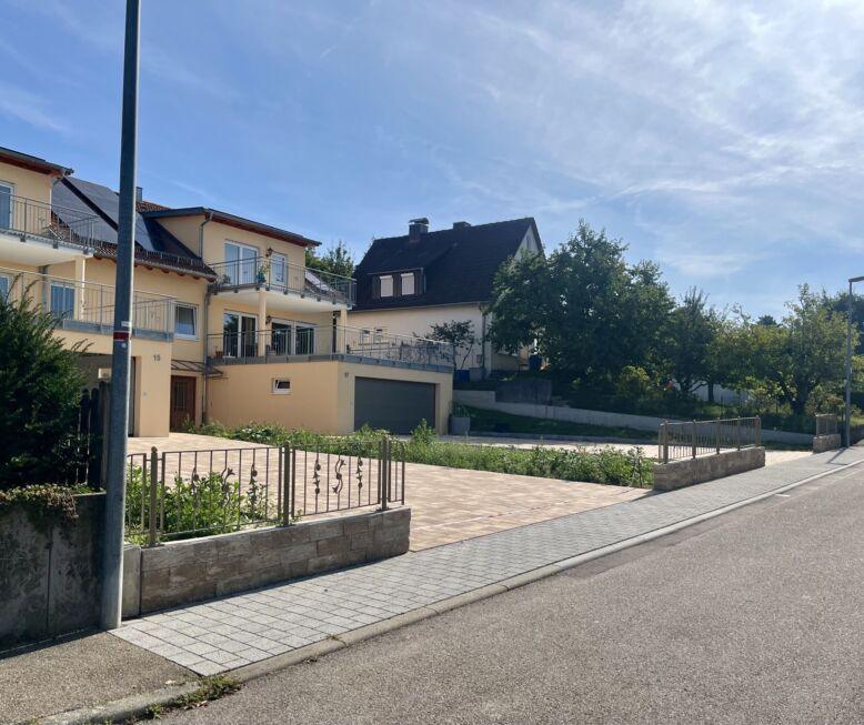 Zaunanlage mit Zierstäben auf Brüstungsmauer entlang des Gehwegs vor Wohnhaus