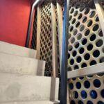 Treppenaufgang mit quadratischem LED-Handlauf und gelochter Metallverkleidung in der MHP-Arena