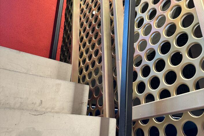 Treppenaufgang mit quadratischem LED-Handlauf und gelochter Metallverkleidung in der MHP-Arena