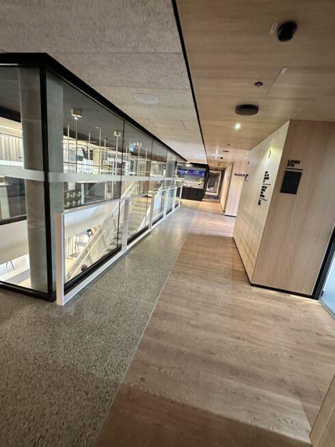 Innenflur der MHP-Arena mit Glasgeländer, Holzverkleidung und moderner Lichtführung