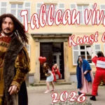 Deckblatt Kalender 2026 Tableau vivant Kunst lebt, historische Figuren und Kunstwächter Szene vor Gebäude, großer Schriftzug „Tableau vivant“ und „Kunst lebt!“ sowie Jahreszahl 2026