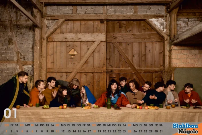 Nachgestellte Szene „Das letzte Abendmahl“ als Tableau vivant, Gruppe sitzt an langer Tafel in rustikalem Holzraum, Brot, Obst und Krug auf dem Tisch