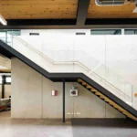 Galerietreppe aus Stahl mit Glasgeländer im Bürogebäude eines Lagerneubaus