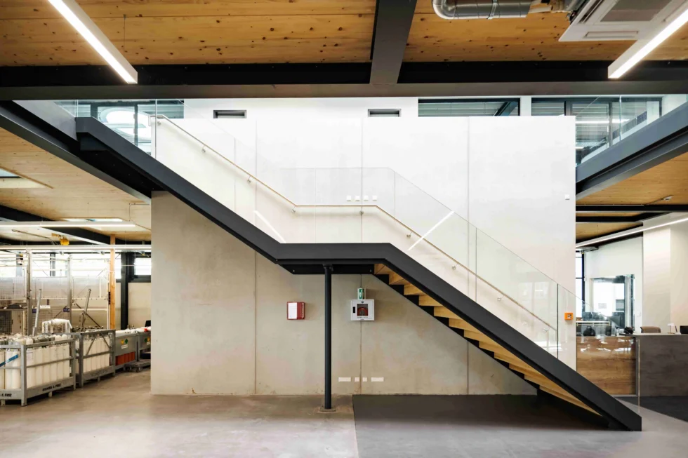 Galerietreppe aus Stahl mit Glasgeländer im Bürogebäude eines Lagerneubaus