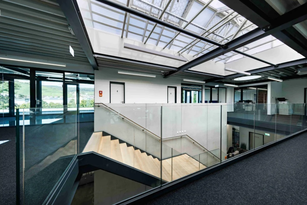 Galerie mit Glasgeländer und Stahltreppe im Bürobereich eines Lagergebäudes