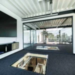 Galerieflur mit Glaswänden und Blick auf die Stahltreppe im Bürogebäude eines Lagerneubaus