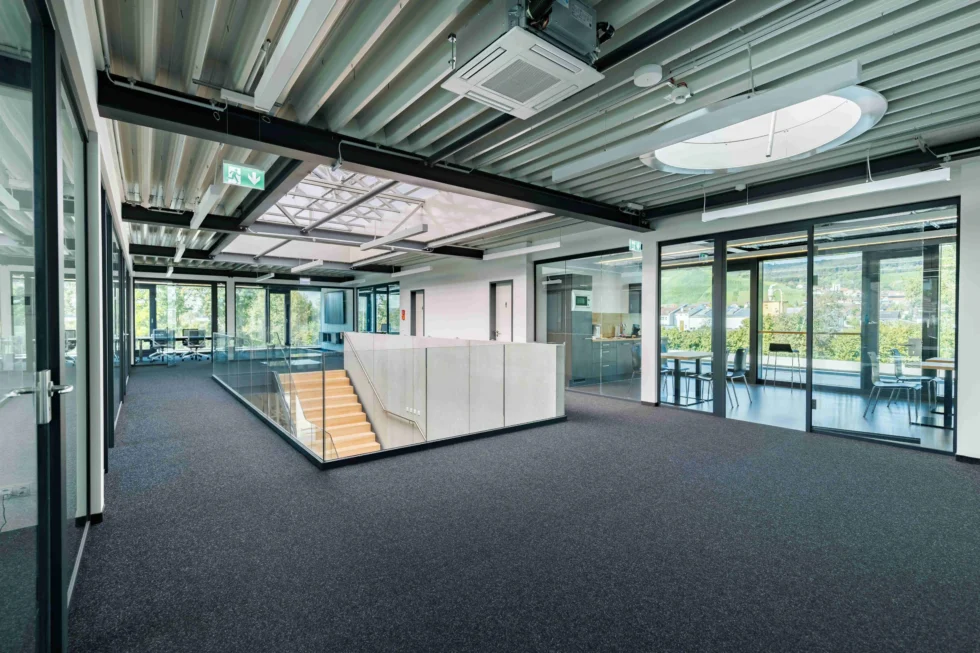 Offene Galerie mit Glasgeländer und Stahltreppe im Bürobereich eines modernen Lagergebäudes