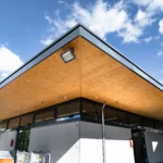 Modernes Lager und Bürogebäude mit auskragendem Dach und Holzuntersicht