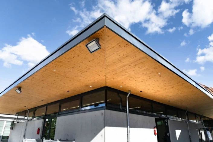 Modernes Lager und Bürogebäude mit auskragendem Dach und Holzuntersicht