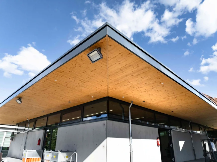 Modernes Lager und Bürogebäude mit auskragendem Dach und Holzuntersicht
