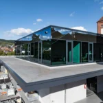 Modernes Bürogebäude mit Glasfassade auf dem Dach eines Lagergebäudes