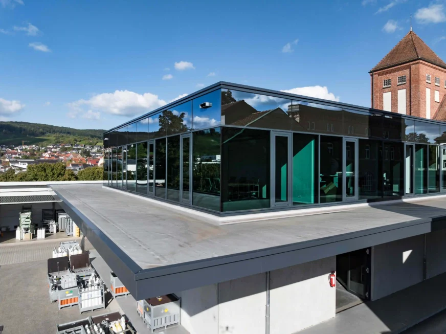 Modernes Bürogebäude mit Glasfassade auf dem Dach eines Lagergebäudes