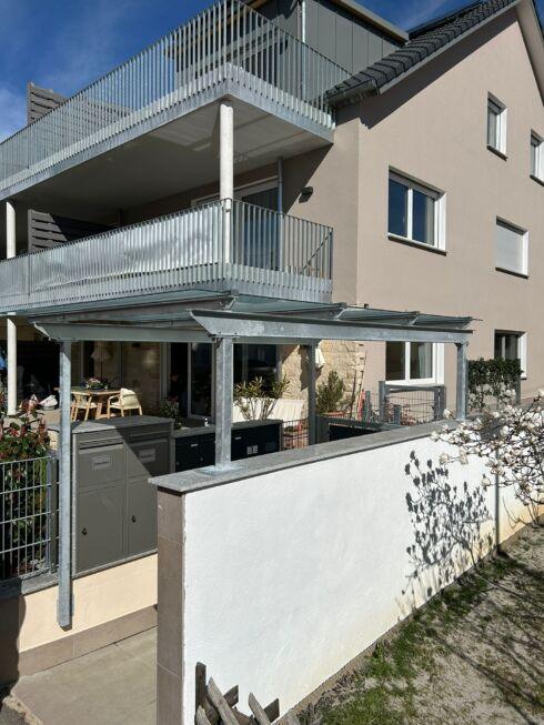 Stahl Überdachung mit Glas über Briefkastenanlage im Eingangsbereich eines Mehrfamilienhauses