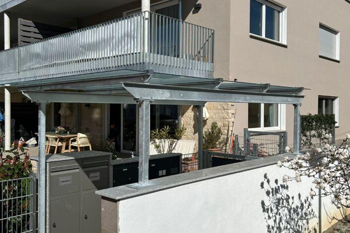 Stahl Überdachung mit Glas über Briefkastenanlage im Eingangsbereich eines Mehrfamilienhauses