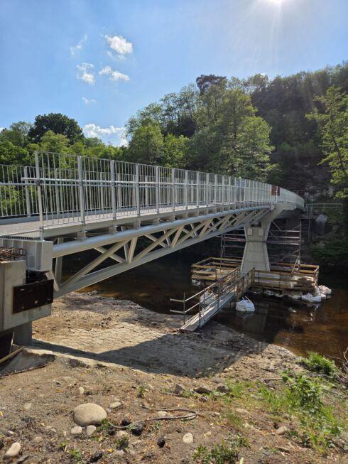 Moderne Stahlbrücke mit Fachwerkkonstruktion, Geländern und Flussquerung