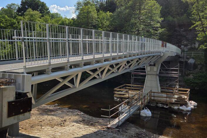 Moderne Stahlbrücke mit Fachwerkkonstruktion, Geländern und Flussquerung