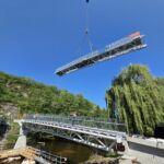 Montage einer 50 Meter langen Stahlbrücke mit Fachwerkkonstruktion per Kran