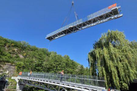 Montage einer 50 Meter langen Stahlbrücke mit Fachwerkkonstruktion per Kran