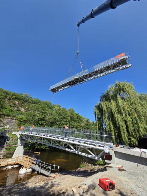 Montage einer 50 Meter langen Stahlbrücke mit Fachwerkkonstruktion per Kran
